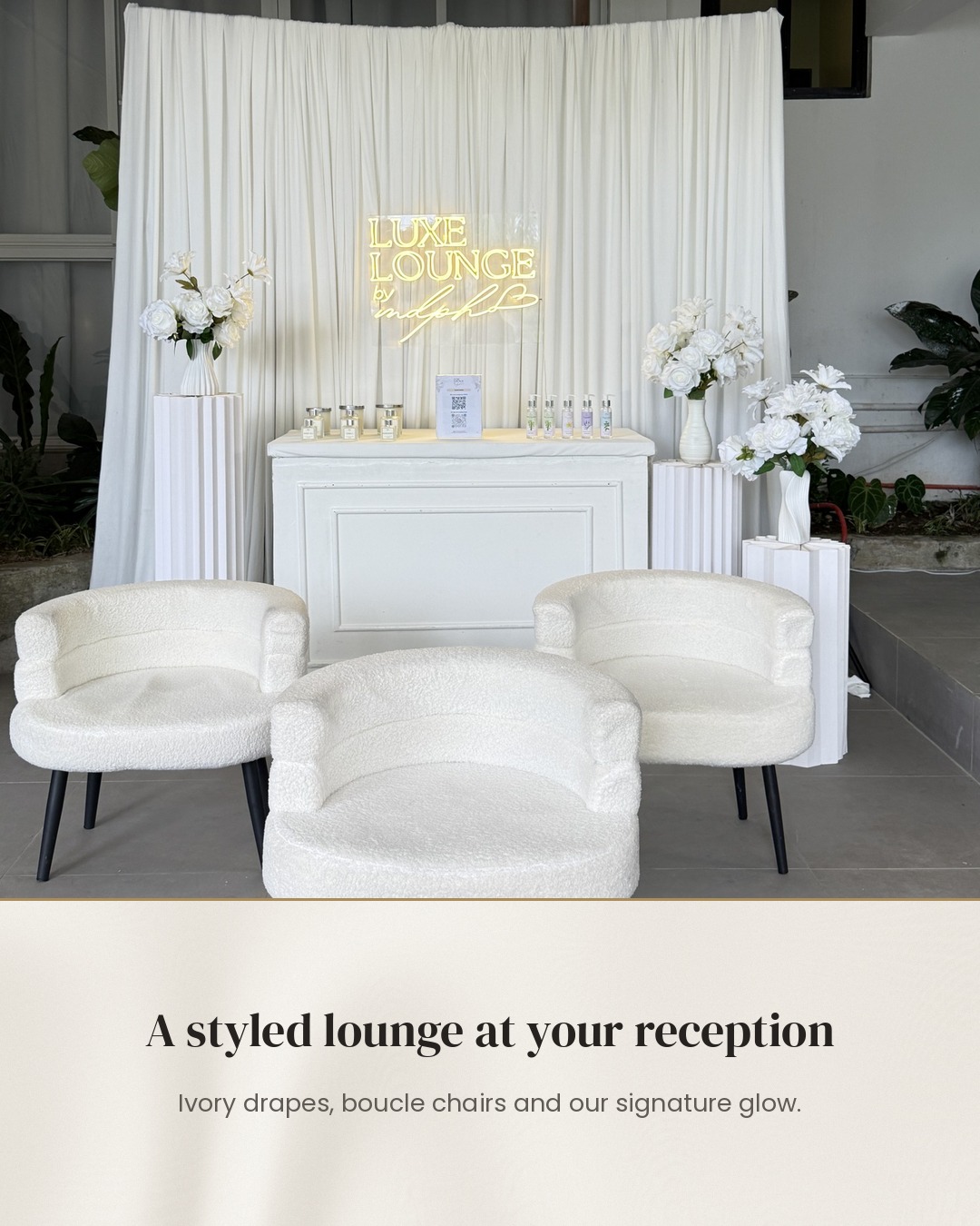 Luxe Lounge reception setup with ivory drapes, white chairs, flowers, and the signature glowing logo